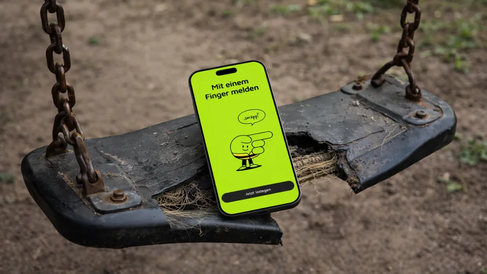 Eine defekte Kinderschaukel auf dem Smartphone mit der App smapp liegt (KI)